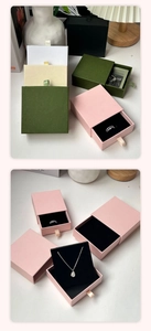 Detail view of drawer-style jewelry gift boxes in multiple colors with ring and necklace