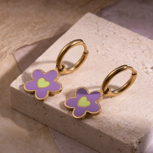 Boucles d'oreilles fleurs dorées avec pétales violets et cœur vert sur socle