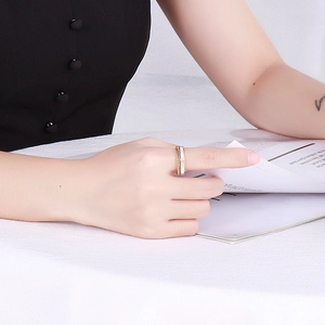 Detail of layered gold stainless steel ring with white shell inlay and chain design