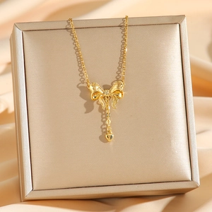 Elegante goldene Schleifenkette mit Herzanhänger auf Schmuckschatulle mit Champagner-Seide