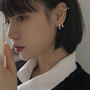 Detail view of 925 silver pearl ear cuff and square zircon earrings on female model