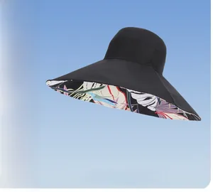 Close-up of a wide brim sun hat featuring a colorful tropical leaf pattern inner lining