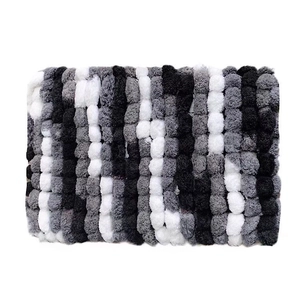 Handmade chunky knit chenille blanket with black white and grey striped pom-pom texture