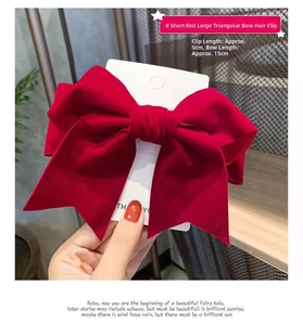 Detail of red oversized satin bow hair clip with a 15cm width and 5cm base clip size