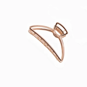 Macro view of rose gold zinc alloy semicircular hair claw with metal spring and teeth