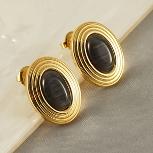 Close-up of vintage gold stud earrings with oval dark gray cat eye stone inlay