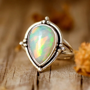 Gros plan d'une bague vintage en argent avec opale en goutte et détails granulés