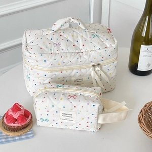 Detailed set of two quilted makeup bags featuring colorful dots and bow patterns