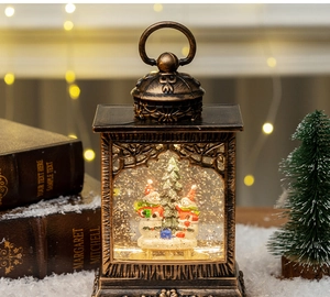 Detail of vintage Christmas snow globe lantern with snowmen and warm glowing light effect