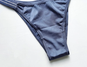 Detail of blue low-rise ice silk panties showing zigzag stitching and elastic side straps