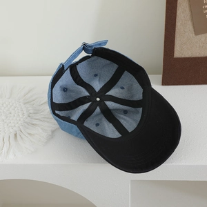 Detail showing inner structure of blue denim baseball cap with silver metal buckle