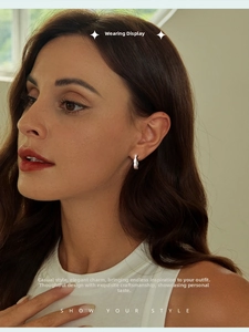 Close-up of a silver twisted hoop earring on a model with elegant side lighting