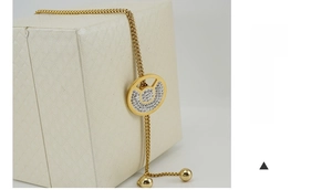 Macro shot of 18K gold plated adjustable slider bracelet with a sparkling crystal charm