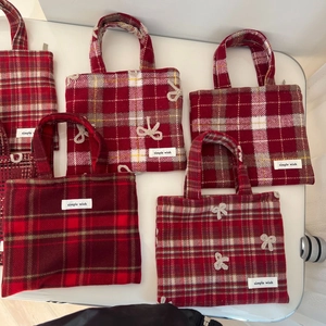 Vue à plat de plusieurs sacs à main en laine à carreaux rouges avec nœuds crochetés