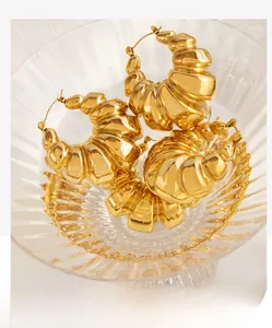 Macro detail of chunky gold plated 18K stainless steel croissant hoop earrings