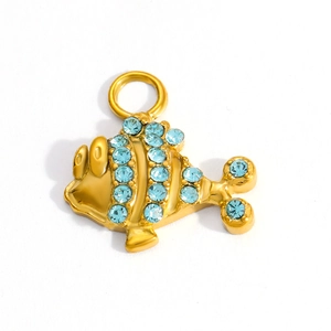 Macro detail of fish-shaped gold pendant with light blue crystal rhinestones