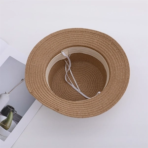 Detail of straw sun hat interior showing beige sweatband and adjustable drawstring