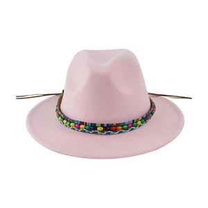 Pink wool felt fedora with colorful ethnic beads and ribbon on white background