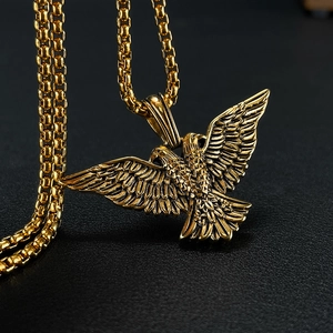 Detailed view of golden double-headed eagle pendant with intricate feather textures