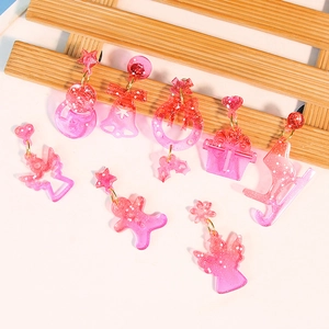Pink glitter resin Christmas earrings set featuring star, bell, and gingerbread man shapes