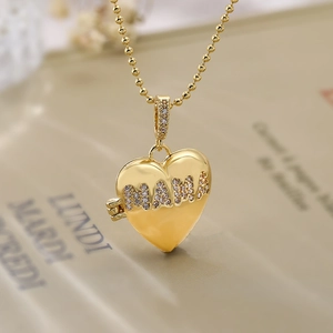 Gold heart locket necklace with MAMA diamond inlay and beaded chain in macro view