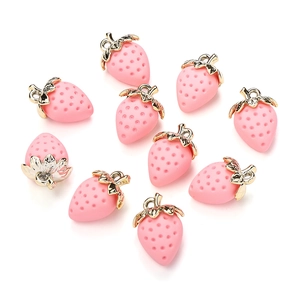 Detail view of 10 pink resin strawberry charms with gold leaf metal loops on white background