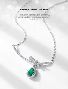Macro detail of bow-knot design and pear-cut emerald drop on the silver necklace