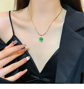 Close-up of vintage gold beaded necklace with an oval green cat eye stone pendant