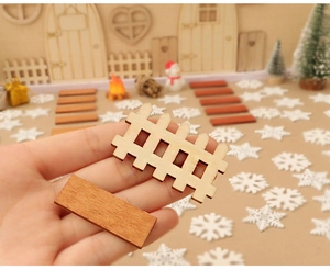 Close-up of miniature wooden fence and sled board for DIY Christmas scene decor