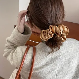 Champagne gold satin scrunchie with pleated silk texture for retro ponytail hairstyles
