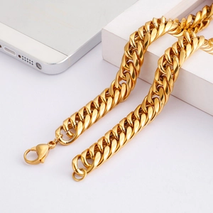 Macro detail of golden Cuban link chain featuring a secure lobster clasp and glossy finish