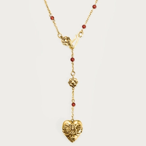 Détail du pendentif cœur en or 18K avec motifs baroques et perles rouges élégantes