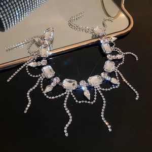 Exquisite close-up of crystal fringe necklace with large rectangular stones on black surface