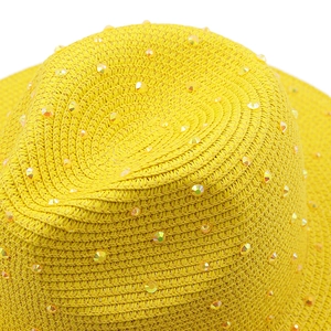 Close-up of yellow Panama straw hat featuring sparkling rhinestone embellishments