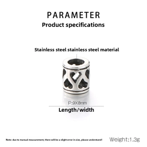 Détail d'une perle cylindrique en acier inoxydable avec motifs de cœurs ajourés
