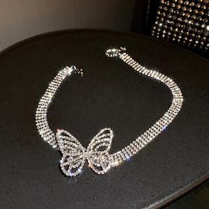Macro shot of silver butterfly necklace with sparkling crystals on dark jewelry tray