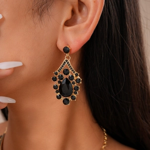 Macro shot of vintage black gemstone teardrop earring with gold finish and rhinestones