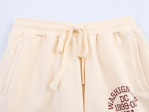 Dettaglio degli shorts crema che mostra vita elastica con stampa WASHIGNTON DC 1999