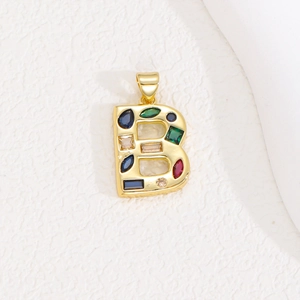 Detailed macro view of a gold-toned letter B pendant with colorful zircon crystal stones