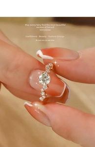 Close-up of rose gold wave ring with round moissanite stone and side diamond accents