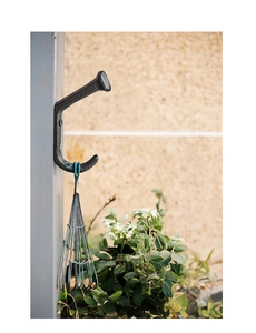 Close-up of industrial cast iron double J-hook with matte texture for gardening tools