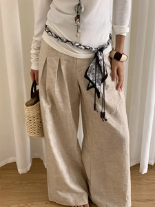 Détail de la ceinture foulard en soie avec perles sur un pantalon large beige