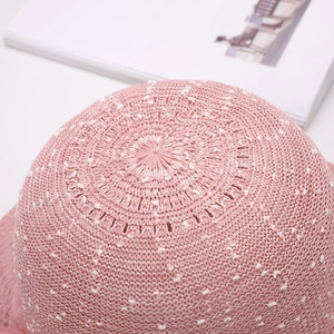 Dettaglio macro del cappello di paglia rosa con trama intrecciata e maglia traspirante