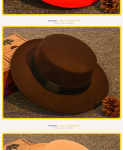 Flat top dark brown children's cotton hat with ribbon detail on textured background