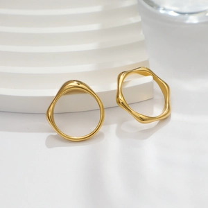 Minimalist 18k gold wave ring with high-polish irregular design on white display stand
