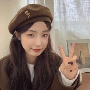 Detailed view of dark brown wool beret featuring a cute 3D teddy bear charm on the side