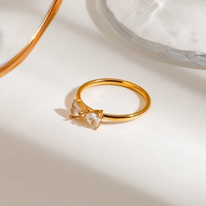 Elegant gold stainless steel ring featuring two interlocking heart-shaped crystals