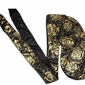 Silky black durag featuring gold rose floral patterns and long compression tail ties