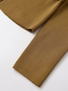 Détail du tissage de la maille premium et des coutures du poignet sur la robe jaune moutarde