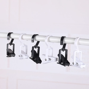 Detail of black and white plastic swivel clips hanging on a rod for closet storage